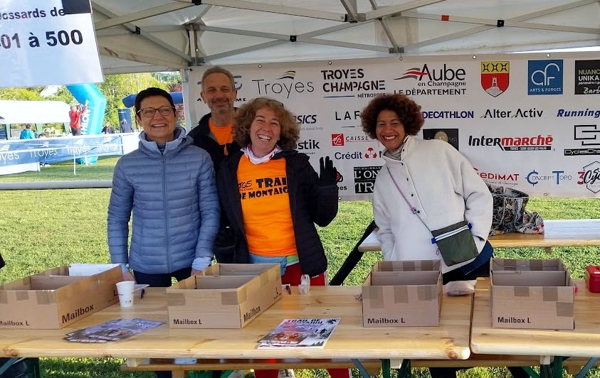 Quatre bénévoles souriants du TOS Athlétisme à la remise des dossards du Trail de Montaigu